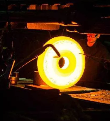 ，需轉(zhuǎn)化為“＞60HRC”或“62-65HRC”等。這是選材最關(guān)鍵、最困難的一步。需根據(jù)鍛件的尺寸及工作時(shí)所承受的載荷，計(jì)算出應(yīng)力分布，再由工作應(yīng)力、使用壽命或安全性與材料性能指標(biāo)的關(guān)系，確定性能指標(biāo)的具體數(shù)值。  圖片  3.材料的預(yù)選  根據(jù)對(duì)鍛件材料性能指標(biāo)數(shù)據(jù)的要求查閱有關(guān)手冊(cè)，找到介適的材料，由這些材料的大致應(yīng)用范圍可進(jìn)行判斷、選材。用預(yù)選材料設(shè)計(jì)的鍛件，其危險(xiǎn)截而在考慮安全系數(shù)后的工作應(yīng)力，必須小于所確定的件能指標(biāo)數(shù)據(jù)值。然后再比較加工工藝的可行性和制造成本的高低，以最優(yōu)方案的材料作為所選定的材料。通過(guò)試驗(yàn)和研究不斷優(yōu)化篩選，使高、中、低檔的選材集中到少數(shù)幾個(gè)鋼種。這樣不但有利于提高原材料質(zhì)量，還能使鍛件制造的各工藝過(guò)程易于控制。